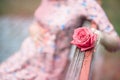 Pregnant woman touching bump whilst holding pink rose girl waiting