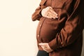 Pregnant woman touching her belly on beige background, closeup. Space for text Royalty Free Stock Photo