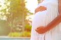 Pregnant woman touching her belly with love in nature Royalty Free Stock Photo