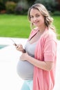 Pregnant woman touching her belly and texting Royalty Free Stock Photo