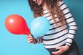 Pregnant woman tries to guess the boy or girl. Balloons as symbol of boy and girl.