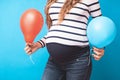 Pregnant woman tries to guess the boy or girl. Balloons as symbol of boy and girl.