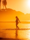 Pregnant woman at tropical beach with bright sunrise or sunset tones Royalty Free Stock Photo
