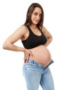 Pregnant woman trying to fit in tight jeans Royalty Free Stock Photo