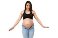 Pregnant woman trying to fit in tight jeans Royalty Free Stock Photo