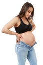 Pregnant woman trying to fit in tight jeans Royalty Free Stock Photo