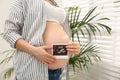 Pregnant woman with ultrasound photo of her baby at home Royalty Free Stock Photo