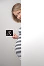 Pregnant woman peeking out of white wall Royalty Free Stock Photo