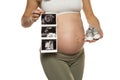 Pregnant woman with ultrasound scan pictures and pair of gray baby sneakers on a white background