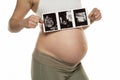 Pregnant woman with ultrasound scan pictures on a white background