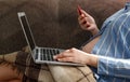 A young pregnant woman is working at a laptop with a smartphone in her hands. Ordering goods via the Internet or remote Royalty Free Stock Photo