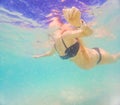 Pregnant woman underwater swimming in tropical sea. Healthy and active pregnancy. Young expecting mom on summer beach Royalty Free Stock Photo