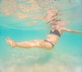 Pregnant woman underwater swimming in tropical sea. Healthy and active pregnancy. Young expecting mom on summer beach Royalty Free Stock Photo