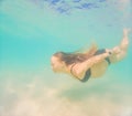 Pregnant woman underwater swimming in tropical sea. Healthy and active pregnancy. Young expecting mom on summer beach Royalty Free Stock Photo