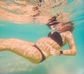 Pregnant woman underwater swimming in tropical sea. Healthy and active pregnancy. Young expecting mom on summer beach Royalty Free Stock Photo