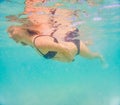 Pregnant woman underwater swimming in tropical sea. Healthy and active pregnancy. Young expecting mom on summer beach Royalty Free Stock Photo