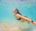 Pregnant woman underwater swimming in tropical sea. Healthy and active pregnancy. Young expecting mom on summer beach Royalty Free Stock Photo