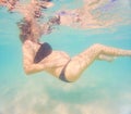 Pregnant woman underwater swimming in tropical sea. Healthy and active pregnancy. Young expecting mom on summer beach Royalty Free Stock Photo