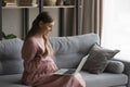 Pregnant woman use laptop makes video call at home Royalty Free Stock Photo