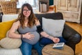 Pregnant woman uses blood pressure meter