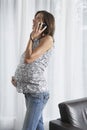 Pregnant Woman Using Mobile Phone At Home Royalty Free Stock Photo