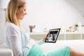 Pregnant woman using tablet to look at sonography results Royalty Free Stock Photo