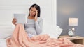 Pregnant, woman and video call for health in home bed with headache and tablet for online consultation. Person with