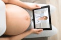 Pregnant Woman Videoconferencing With Doctor