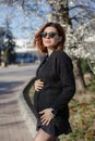 Pregnant woman walking in the park on a sunny spring day Royalty Free Stock Photo