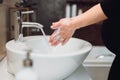 Pregnant woman Washing hands with soap under the faucet with water in bathroom