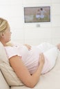 Pregnant woman watching television Royalty Free Stock Photo