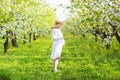 Pregnant woman wearing big hat and white dress in blooming garden Royalty Free Stock Photo