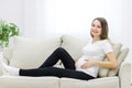 Pregnant woman wearing casual clothes on white sofa. Royalty Free Stock Photo