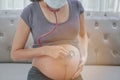 A pregnant woman wears a surgical mask and checking her fetus by stethoscope. Protect a COVID-19 Coronavirus, PM 2.5 and prevent