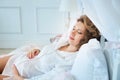 Pregnant woman in white blouse lying on bed. Sleap