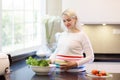 Pregnant woman in white kitchen. Healthy pregnancy