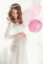 Pregnant woman in a white nightgown with balloons. Royalty Free Stock Photo