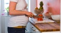 Pregnant woman in a white shirt cutting tomatoes in the kitchen Royalty Free Stock Photo