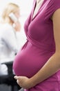 Pregnant woman at work holding belly with coworker Royalty Free Stock Photo