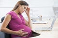 Pregnant woman at work looking stressed