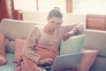 Pregnant woman working on a couch. Royalty Free Stock Photo