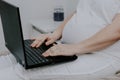 Pregnant woman working on a laptop.