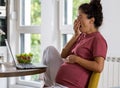 Pregnant woman working on laptop and yawning at home Royalty Free Stock Photo