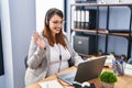 Pregnant woman working at the office wearing operator headset looking positive and happy standing and smiling with a confident Royalty Free Stock Photo