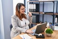 Pregnant woman working at the office wearing operator headset pointing thumb up to the side smiling happy with open mouth Royalty Free Stock Photo