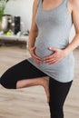 Pregnant woman doing prenatal yoga standing in tree pose Royalty Free Stock Photo