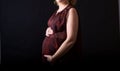 Pregnant women belly dressed in red blouse Royalty Free Stock Photo