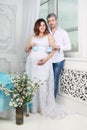 Pregnant woman in dress and man with baby bootees