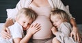 Pregnant woman with her children at home. Third pregnancy. Maternity, family, parenting concept Royalty Free Stock Photo