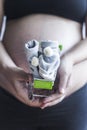 Pregnant women holding shopping cart with baby shoes. Pregnancy shopping item Royalty Free Stock Photo